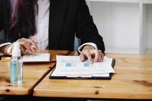 la mujer de negocios apunta a documentar el presupuesto y usa la calculadora para revisar el balance anual para calcular el presupuesto. integridad de la auditoría antes de la inversión. foto