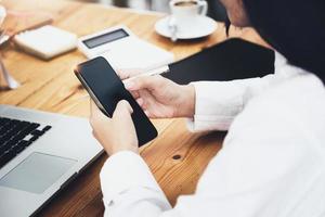 woman using mobile phone and computer to work in home office. photo