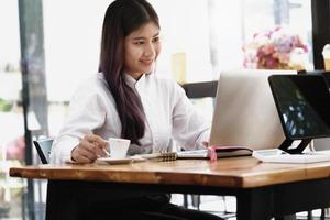 new normal, a businesswoman uses a computer to work for a company Via the internet on your desk at home. photo