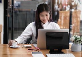 new normal, a businesswoman uses a computer to work for a company Via the internet on your desk at home. photo