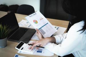 Business owners use calculators to calculate with financial documents to analyze third-party profits to invest in company stocks. photo