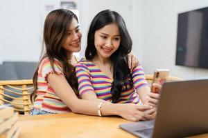 lgbtq, lgbt concept, homosexuality, portrait of two asian women posing happy together and loving each other while playing computer laptop photo