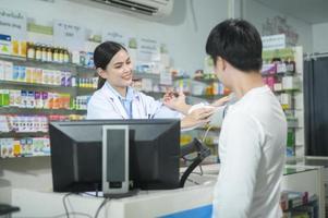 Female pharmacist counseling customer about drugs usage in a modern pharmacy drugstore. photo