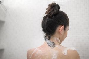 Happy beautiful woman is taking a shower photo