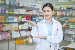 Portrait of female pharmacist working in a modern pharmacy drugstore. photo