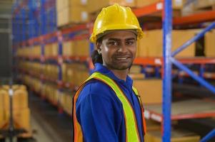 Portrait of young mixed race male worker wearing helmet in modern warehouse storage of retail shop photo