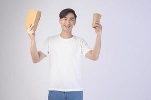 Young asian man holding paper cup and paper box over white background, Save earth concept photo