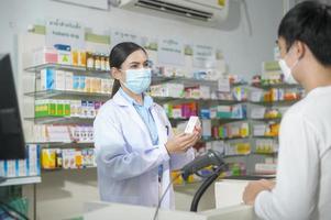 Portrait of female pharmacist wearing face mask in a modern pharmacy drugstore. photo