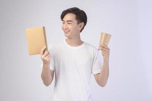 joven asiático sosteniendo un vaso de papel y una caja de papel sobre fondo blanco, salva el concepto de tierra foto