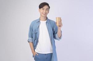 Young asian man holding paper cup  over white background, Save earth concept photo