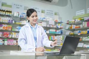 una farmacéutica que asesora a una clienta a través de una videollamada en una farmacia moderna. foto