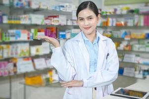 Portrait of female pharmacist working in a modern pharmacy drugstore. photo