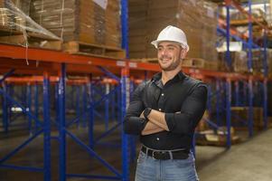 Portrait of young caucasian male worker wearing helmet in modern warehouse storage of retail shop photo