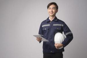 retrato de un ingeniero que lleva un casco protector sobre un estudio de fondo blanco. foto