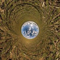 bola de cielo azul en medio del campo giratorio. inversión de la transformación del pequeño planeta del panorama esférico de 360 grados. curvatura del espacio. foto