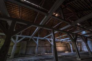 inside dark abandoned ruined wooden decaying hangar with rotting columns photo