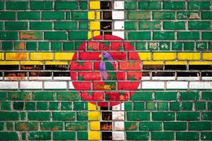 National  flag of the Dominica on a grunge brick background. photo