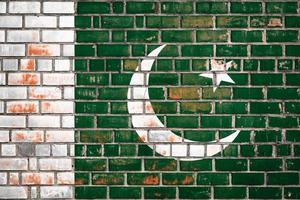 National  flag of the  Pakistan  on a grunge brick background. photo