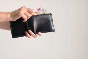 Hands picking money in Thai baht from wallet for paying. photo