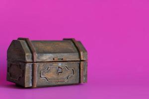 una vieja caja de metal sobre fondo rosa. foto