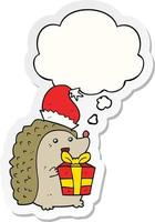 cartoon hedgehog wearing christmas hat and thought bubble as a printed sticker vector