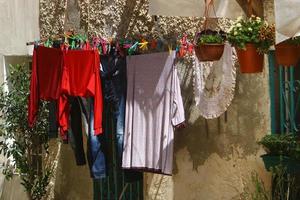 Washed linen dries on the street outside the window of the house. photo