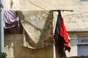 Washed linen dries on the street outside the window of the house. photo