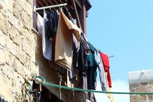 Washed linen dries on the street outside the window of the house. photo