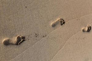 Footprints in the sand on the city beach. photo