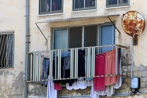 Washed linen dries on the street outside the window of the house. photo