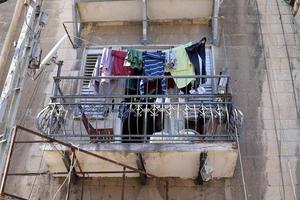 Washed linen dries on the street outside the window of the house. photo