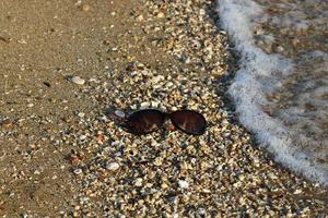 Lost glasses are lying on the sand. photo