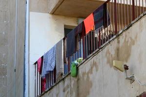 Washed linen dries on the street outside the window of the house. photo