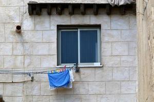 Washed linen dries on the street outside the window of the house. photo
