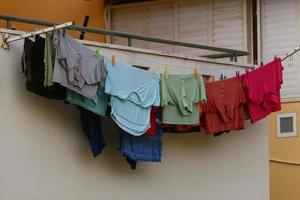 Washed linen dries on the street outside the window of the house. photo