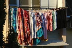 Washed linen dries on the street outside the window of the house. photo