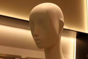 A mannequin stands on a showcase in a large store. photo