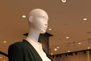 A mannequin stands on a showcase in a large store. photo