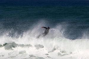 December 21, 2018 Israel. Surfing on high waves in the Mediterranean. photo