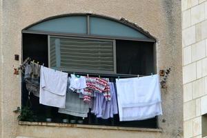 Washed linen dries on the street outside the window of the house. photo