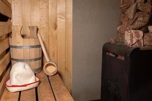 antiguo concepto de spa de la antigua casa de baños rusa. detalles interiores sauna finlandesa sala de vapor con accesorios de sauna tradicional conjunto de fieltro. relájese el concepto de baño de pueblo rural. foto