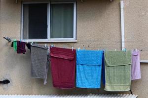 Washed linen dries on the street outside the window of the house. photo