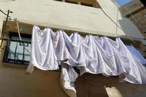 Washed linen dries on the street outside the window of the house. photo