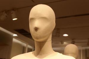 A mannequin stands on a showcase in a large store. photo