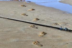 Footprints in the sand on the city beach. photo