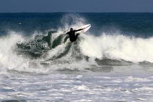 December 21, 2018 Israel. Surfing on high waves in the Mediterranean. photo