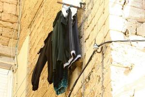 Washed linen dries on the street outside the window of the house. photo