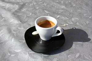 Hot and strong coffee is poured into a cup. photo