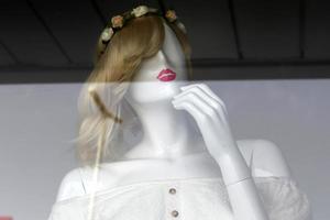 A mannequin stands on a showcase in a large store. photo