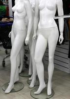 A mannequin stands on a showcase in a large store. photo